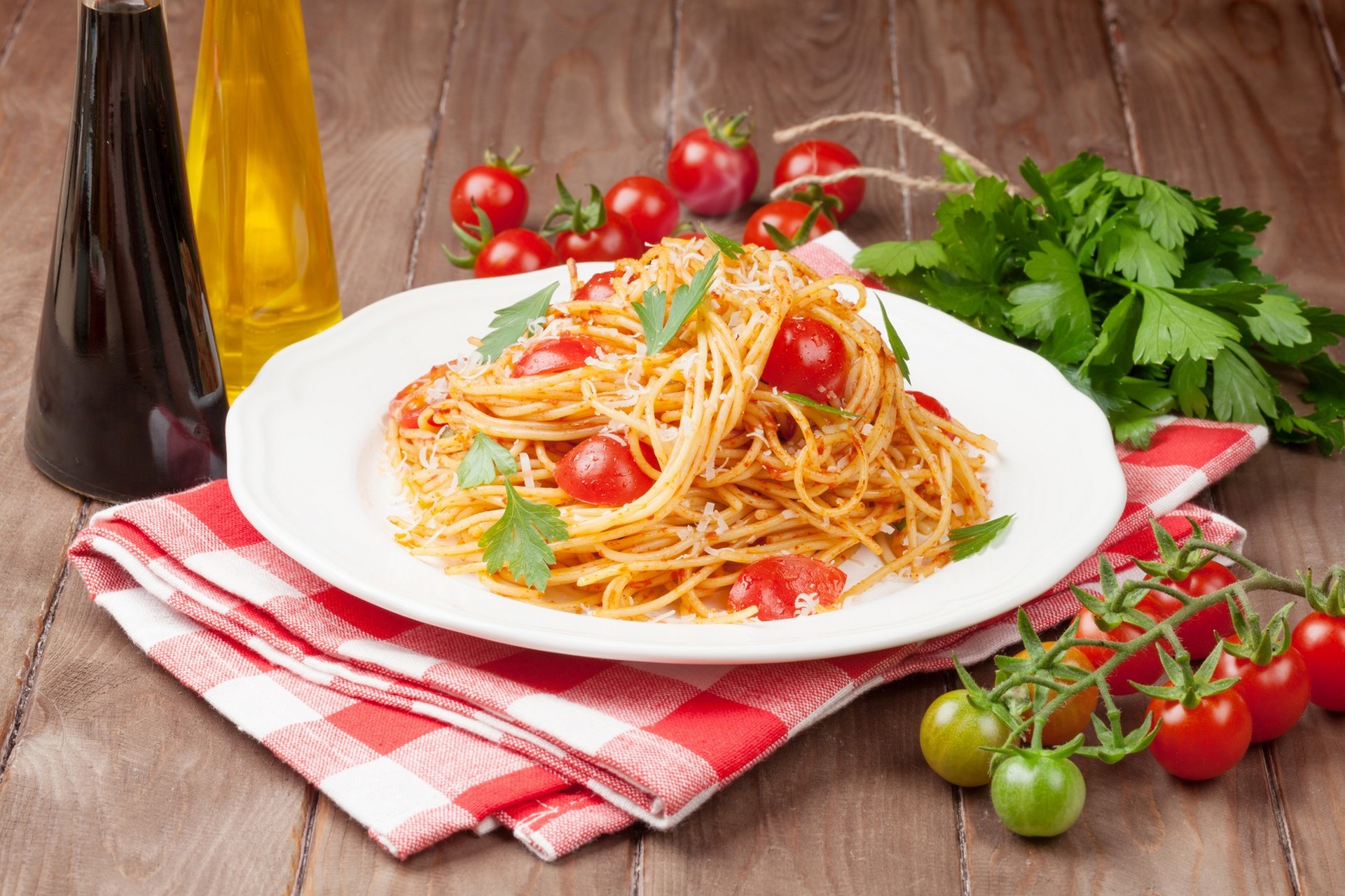 Spaghetti pasta with tomatoes and parsley on wooden table