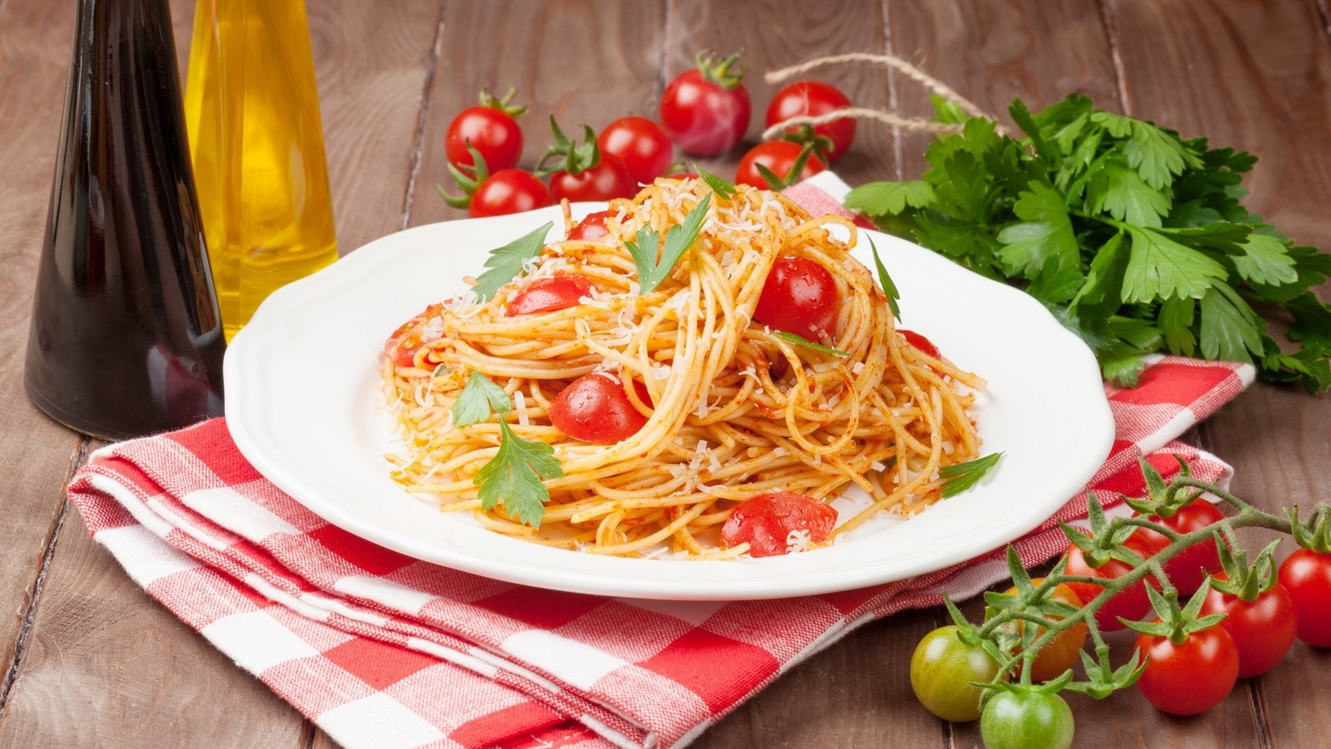 Spaghetti pasta with tomatoes and parsley on wooden table